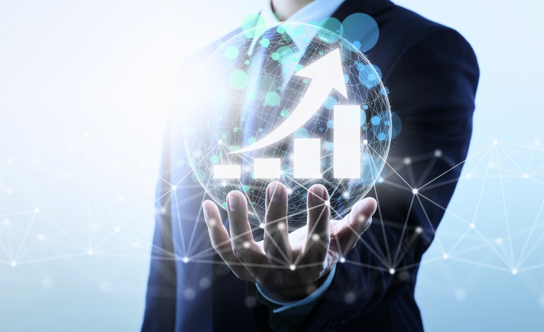 A professional holding a translucent globe with an upward growth arrow, symbolizing cross-border digital asset growth